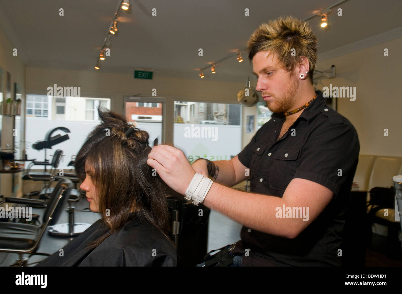 Un adolescente obtener su corte de pelo por una peluquería en una peluquería Foto de stock