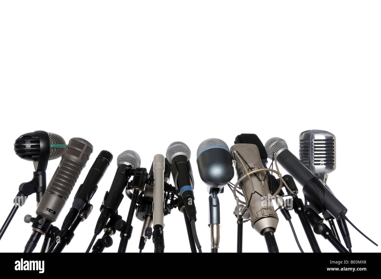 Varios micrófonos alineados en conferencia de prensa aislado sobre un fondo blanco. Foto de stock