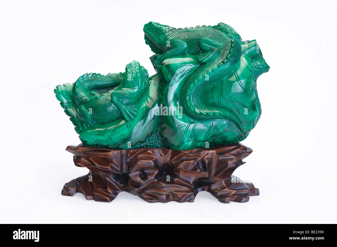 Mineral de Malaquita talla, 'lagartos', pulido sobre fondo blanco. Foto de stock
