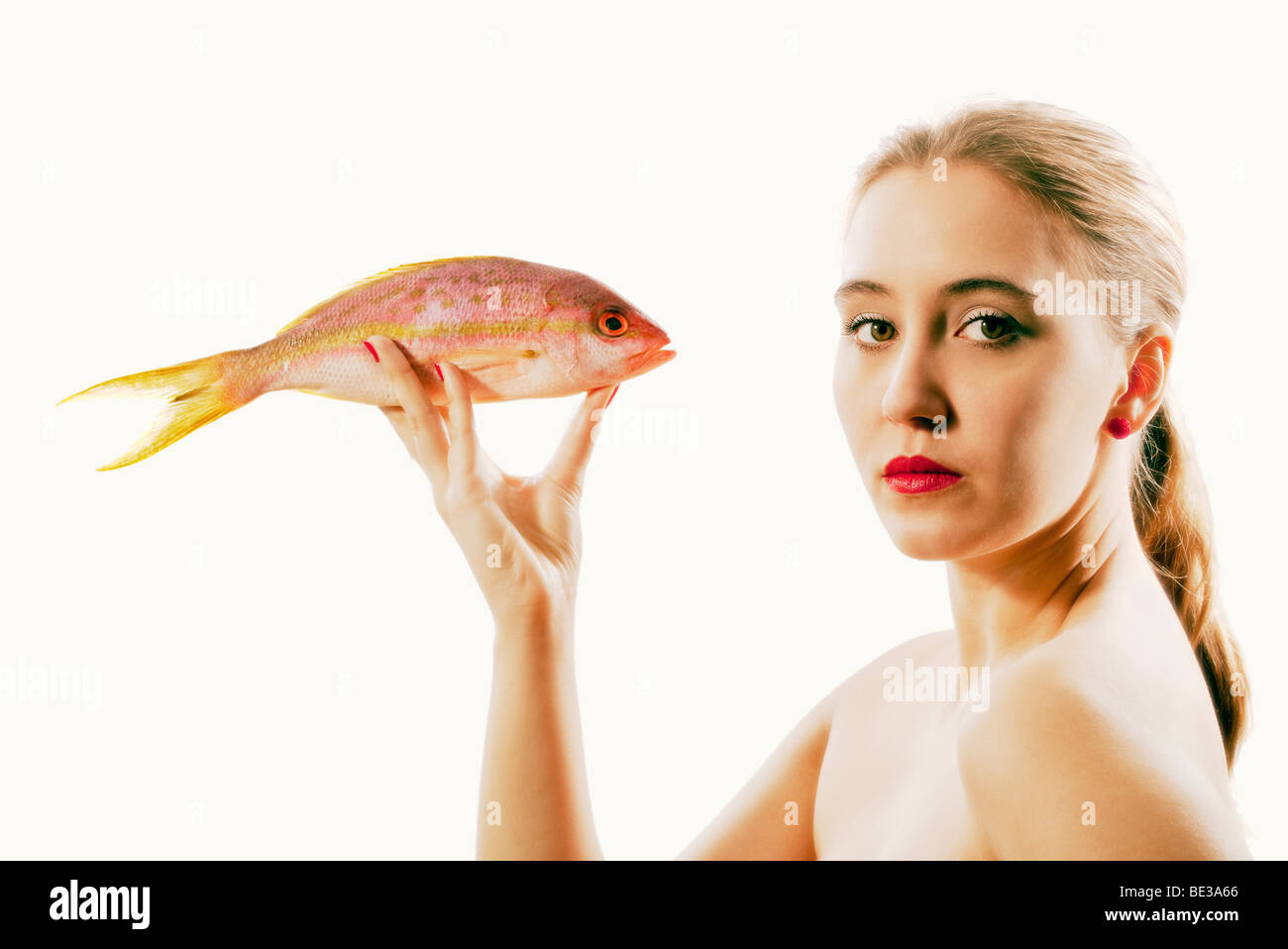 Retrato de estudio de joven la celebración de pescado Foto de stock