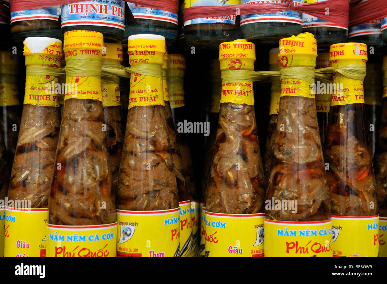 Estantería con la tradicional salsa de pescado vietnamita Nuoc mam en botellas de vidrio con tapón de plástico amarillo, Phu Quoc, Vietnam, Asia Foto de stock