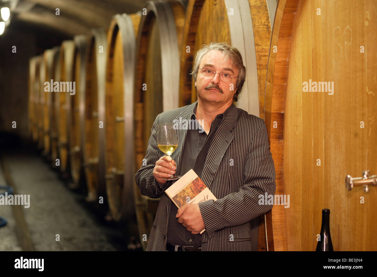 El viticultor Reinhard Heymann-Loewenstein con su libro 'Terroir' en su bodega en Winningen, Renania-Palatinado, Germen Foto de stock