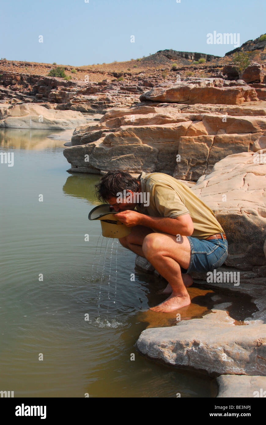 Caminante bebiendo de peces en el río Fish River Canyon, Namibia, África Foto de stock