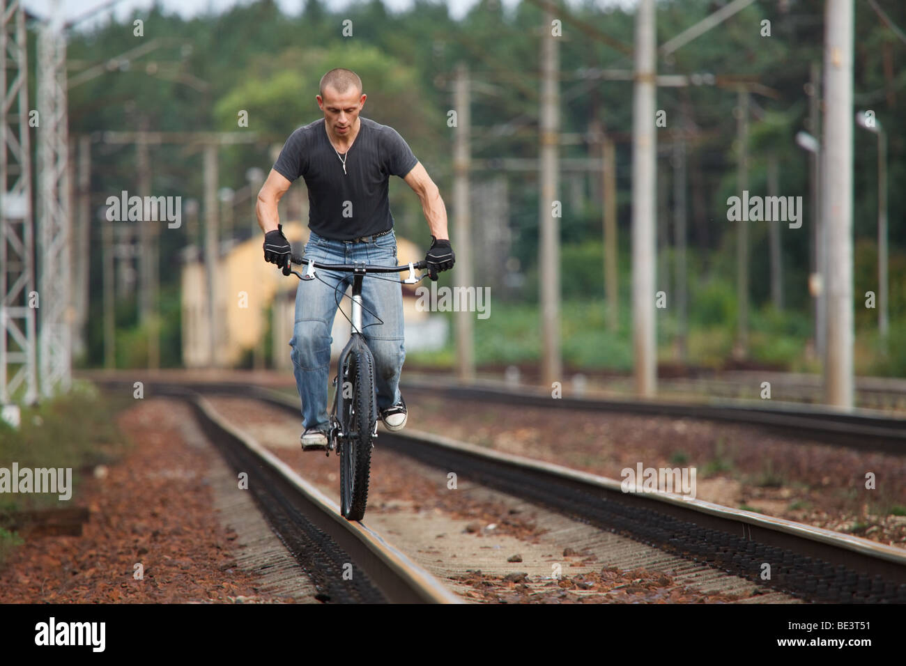 El hombre a caballo con bicicleta en ferrocarril Ferrocarril Foto de stock