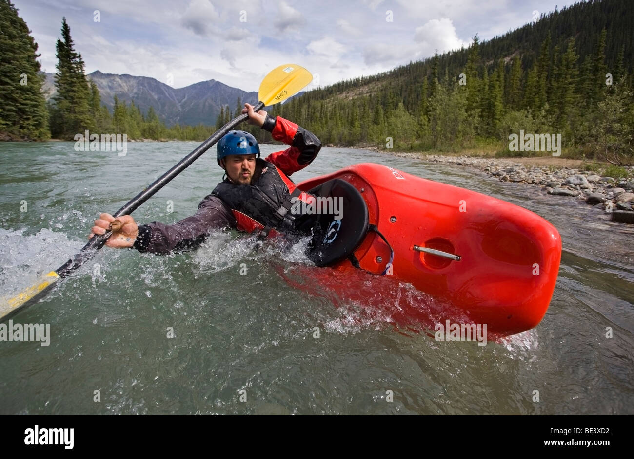Kayak en aguas blancas, el hombre remando un bote play, estabilización de barco, puntal de alta gama, las montañas, las zonas costeras detrás, Wheaton River, Y. Foto de stock
