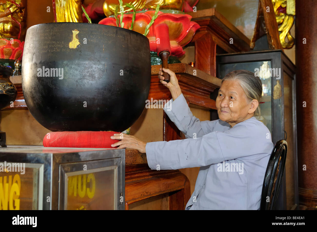 Anciana golpea un tazón de sonido, en un templo en la montaña de la mujer negra, Nui Ba Den, Tay Ninh, Vietnam, Asia Foto de stock