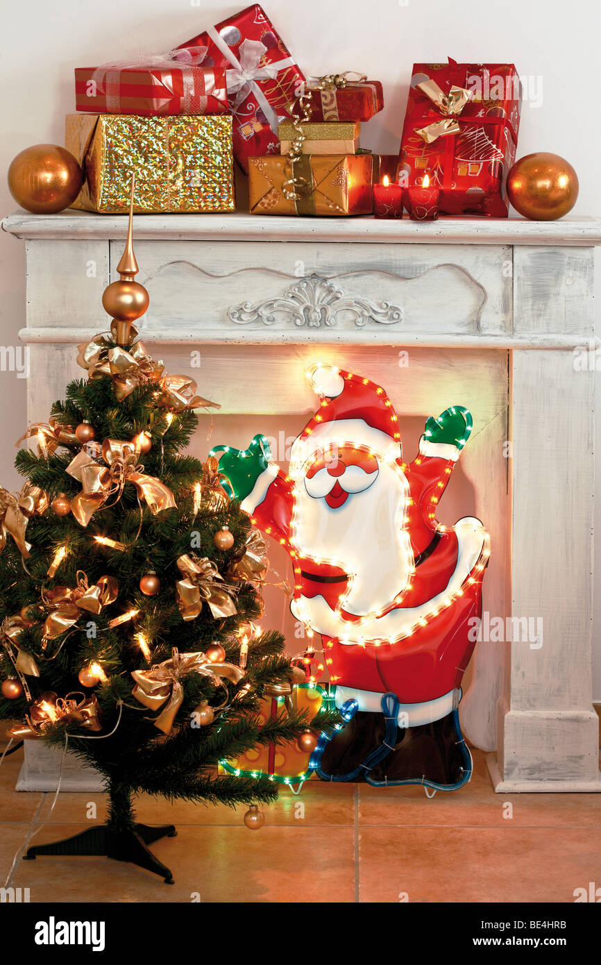 Santa Claus, iluminado árbol de Navidad decorado, con chimenea, presenta en  la parte posterior Fotografía de stock - Alamy