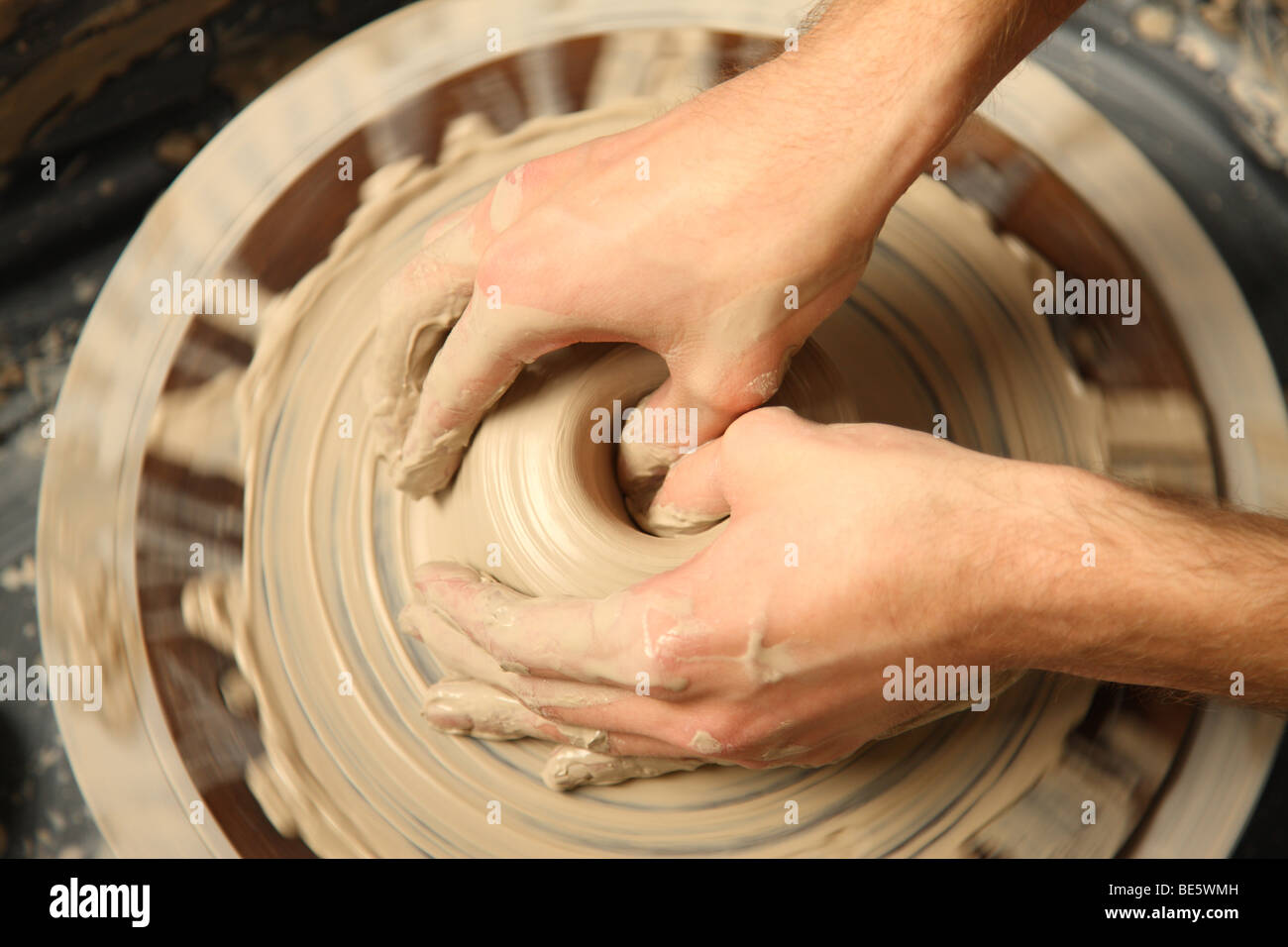 Primer plano de manos trabajando en rueda de alfarería Foto de stock