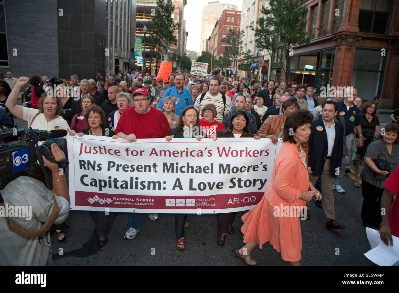 Michael Moore marchas con miembros del sindicato al teatro para nosotros estreno de su nueva película, "Capitalismo, una historia de amor" Foto de stock