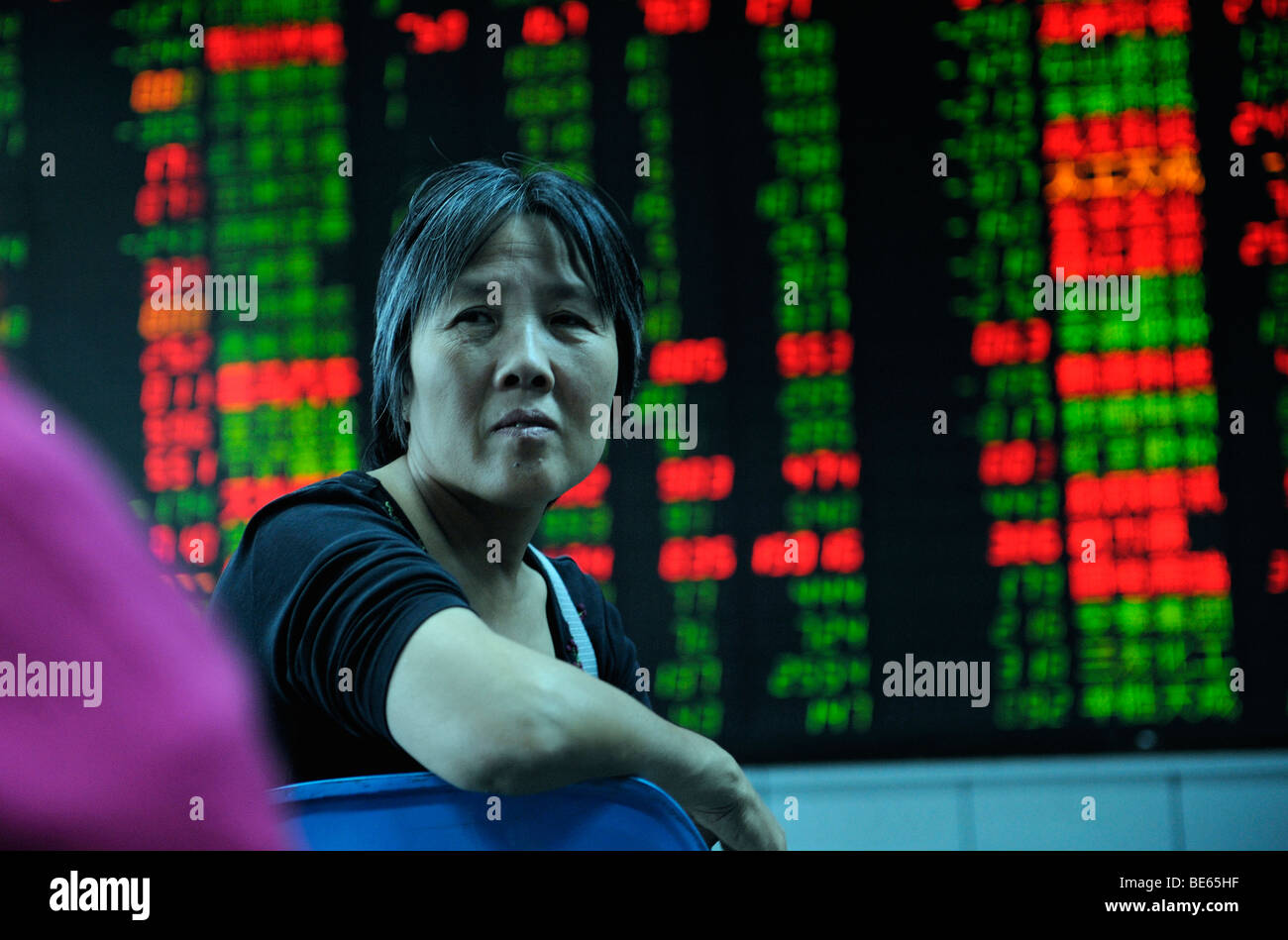 Inversionista Mirar índice bursátil cotizaciones en una empresa de valores en Beijing, China. 21-Sep-2009 Foto de stock