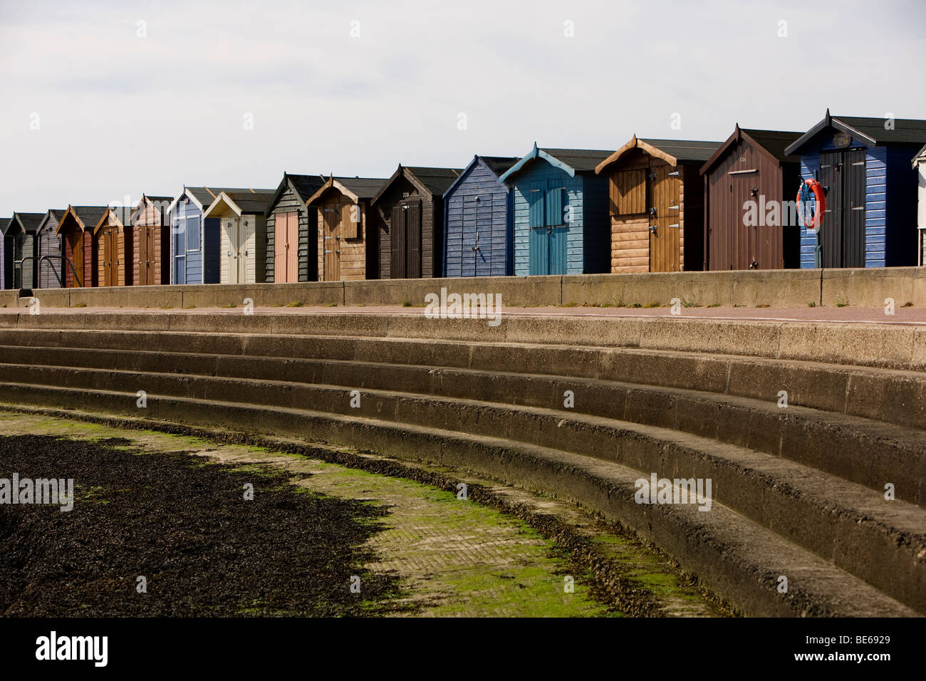 Pintadas cabañas de playa en el paseo marítimo de la ciudad costera de Essex Brightlingsea son la atracción estrella del resort Foto de stock