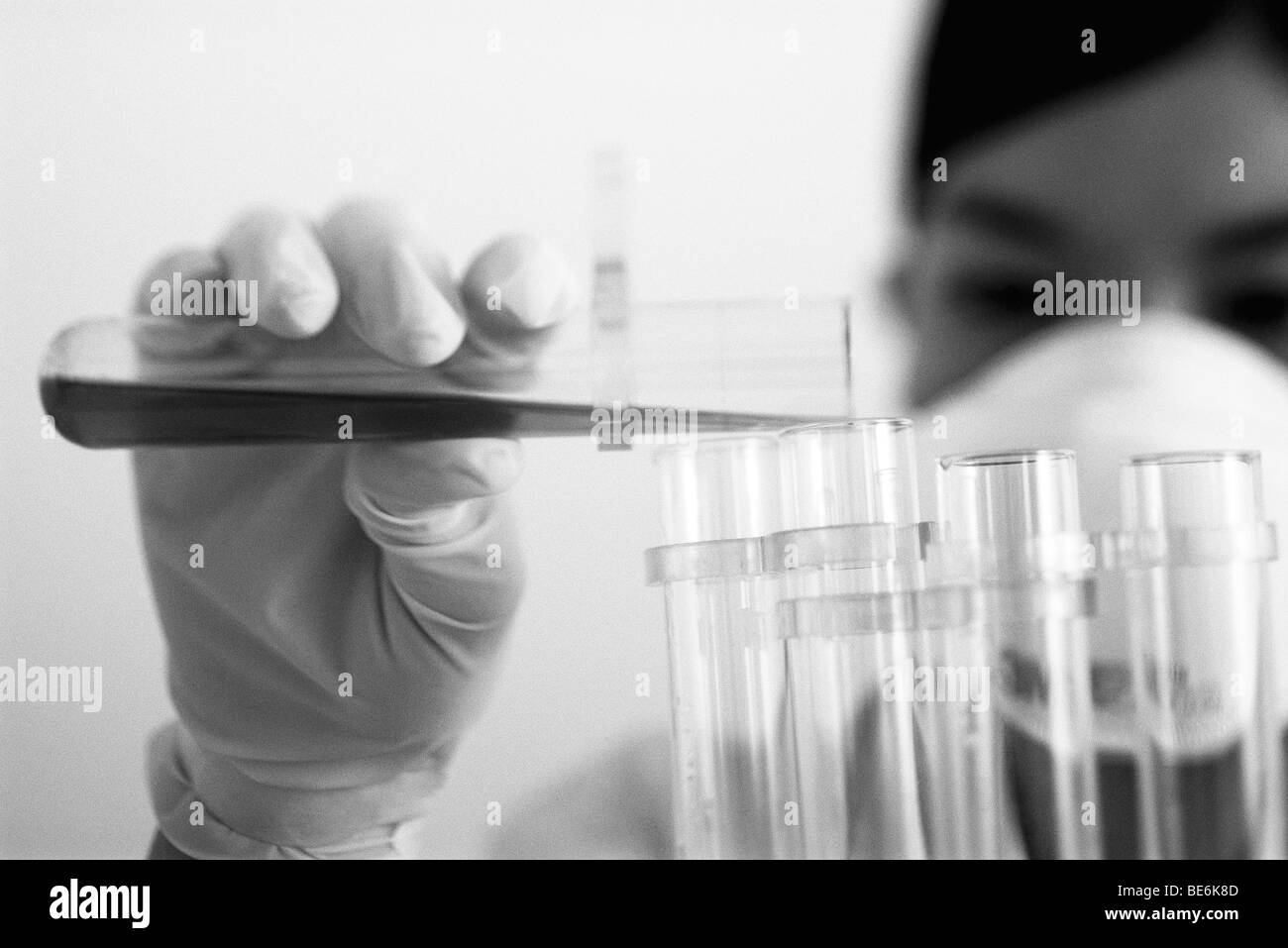 Técnico de laboratorio transferir líquido al tubo de ensayo Foto de stock
