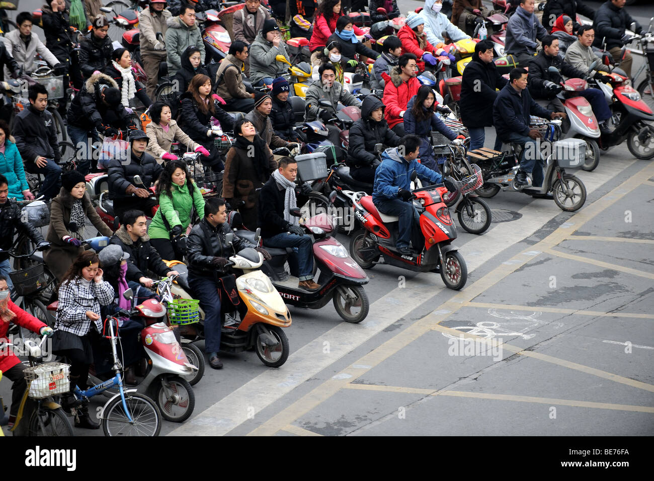 Multitud de bicicletas y motos cruzando en Shanghai, China Foto de stock