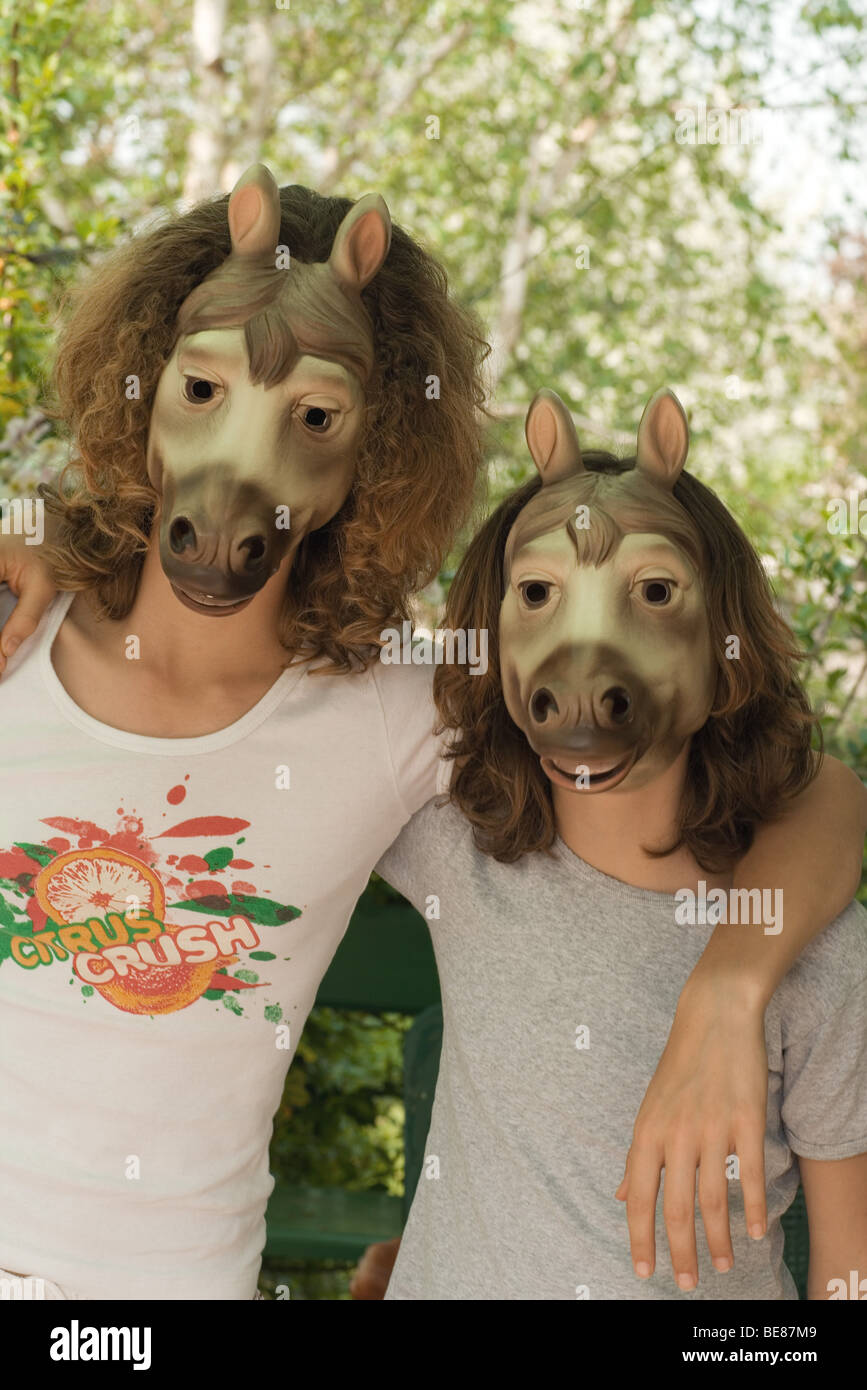 Dos amigos portando máscaras de caballo, los brazos alrededor de cada otros  los hombros Fotografía de stock - Alamy