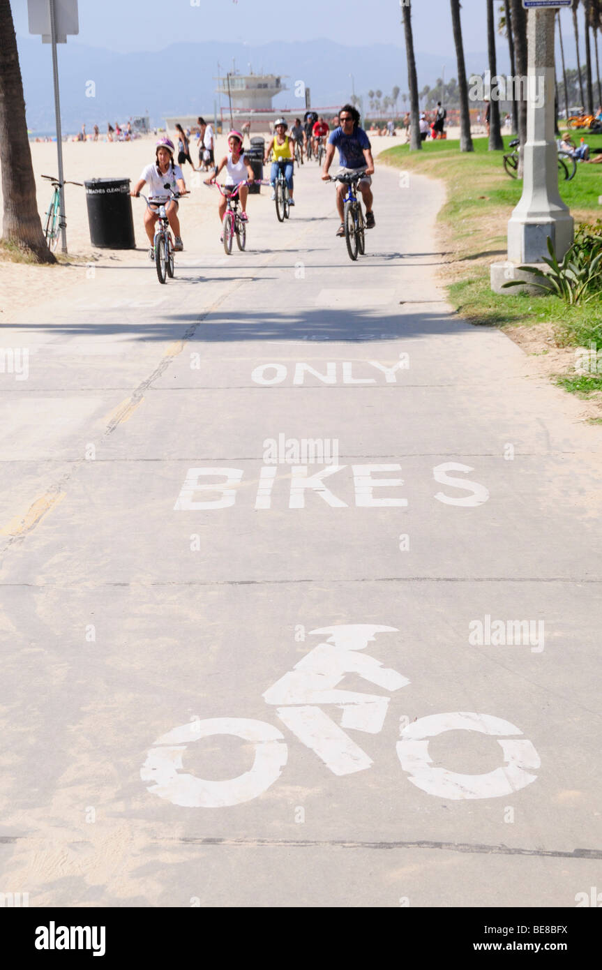 California, Estados Unidos, Los Angeles, South Bay Ruta Ciclista en Venice Beach con bicicletas escrito únicamente sobre asfalto y ciclistas pasar. Foto de stock