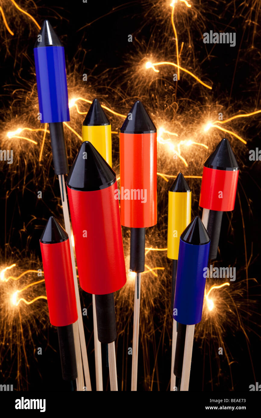Los petardos cohetes con un castillo de fuegos artificiales detrás de ellos Foto de stock