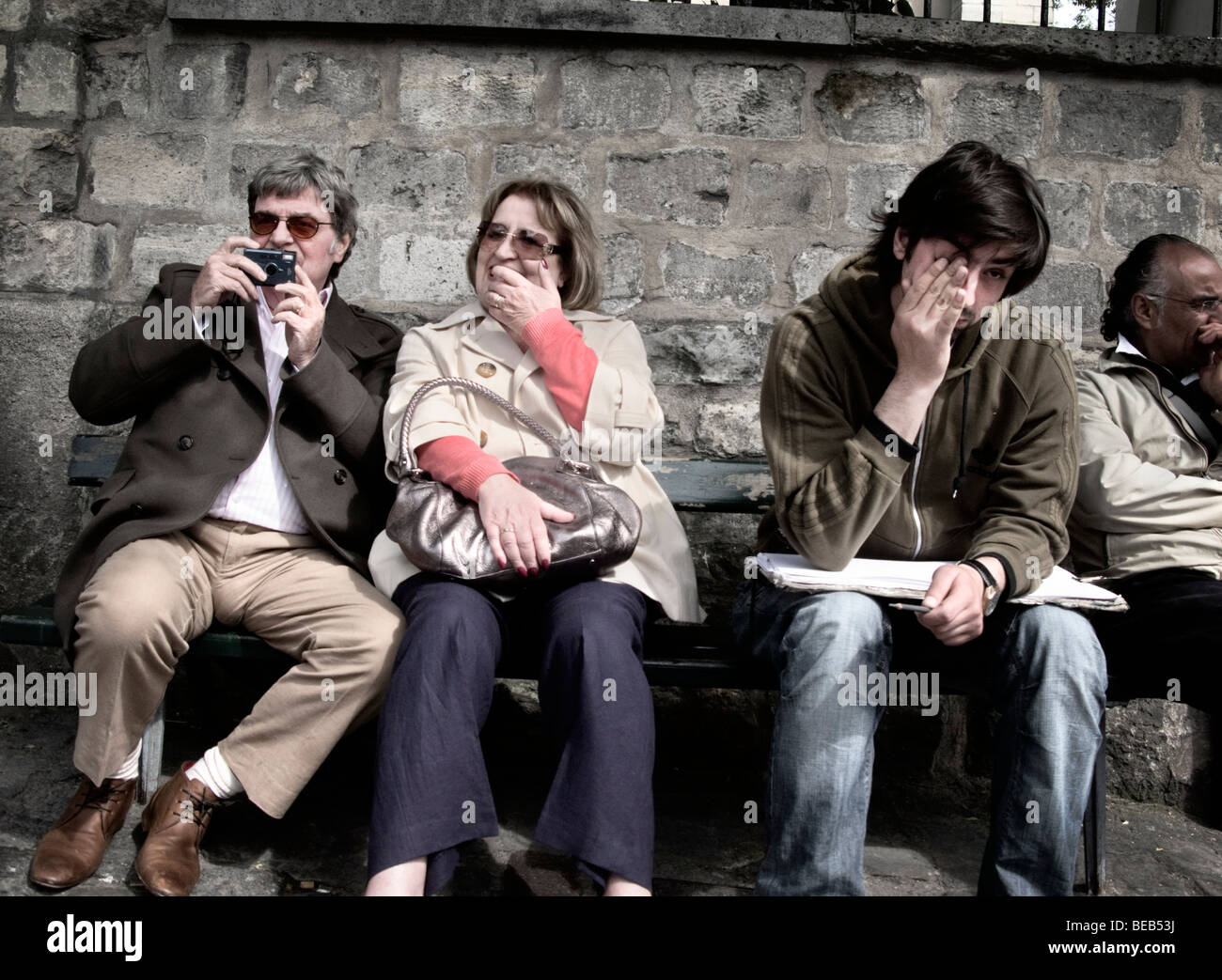 Un grupo de aburridos en busca de turistas esperando en un banco Foto de stock