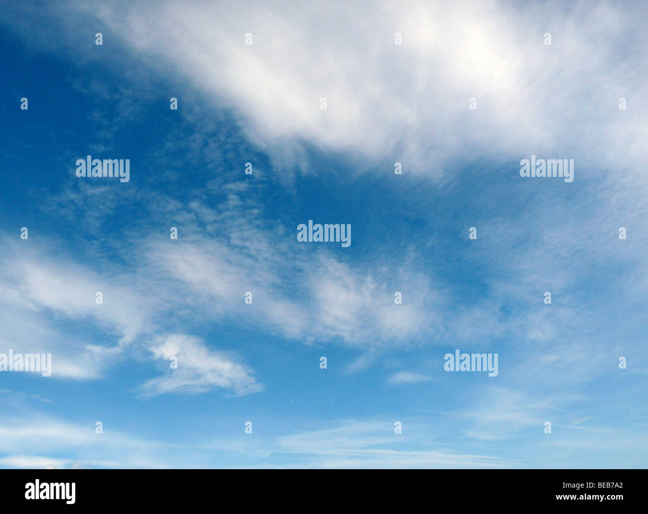 Nubes blancas mullidas contra un cielo azul profundo Foto de stock