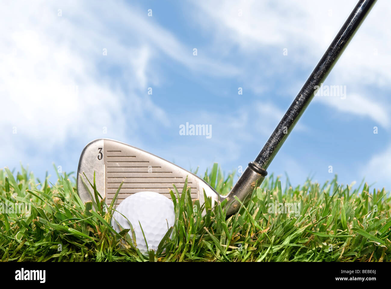 Un golder se prepara para golpear una pelota de golf fuera del áspero durante un hermoso día soleado. Foto de stock