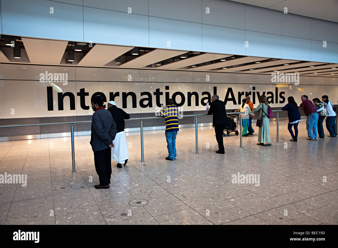 La gente espera de llegadas internacionales del aeropuerto de Heathrow de Londres, Inglaterra Foto de stock