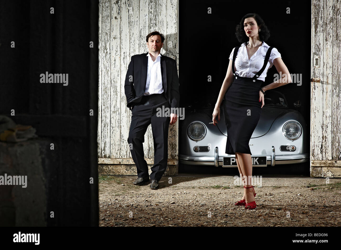 El Chef Mark Baumann posa junto al modelo Fleur y un Porsche Classic Foto de stock