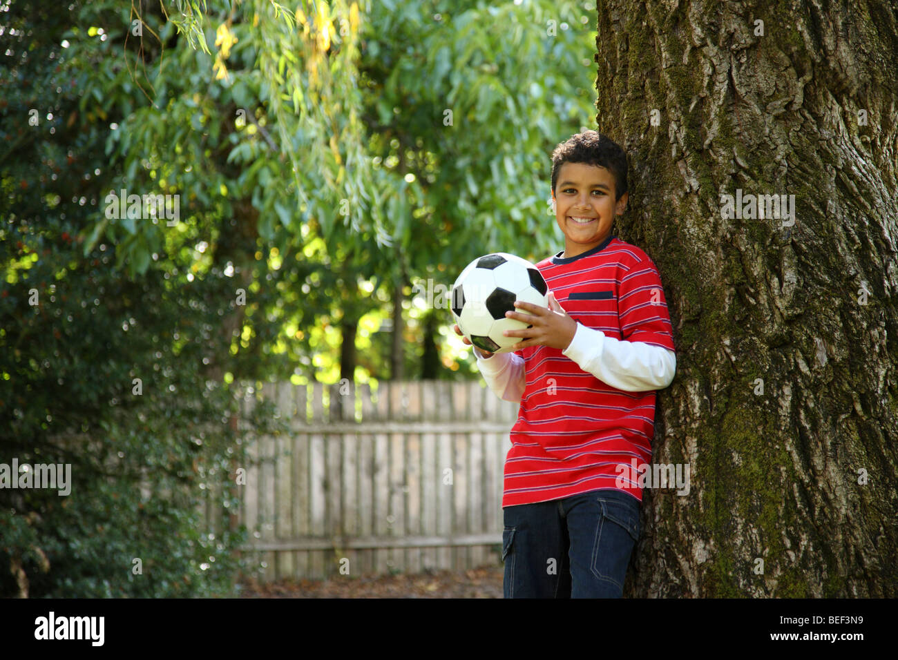 Retrato de niño en el exterior con balón de fútbol Foto de stock
