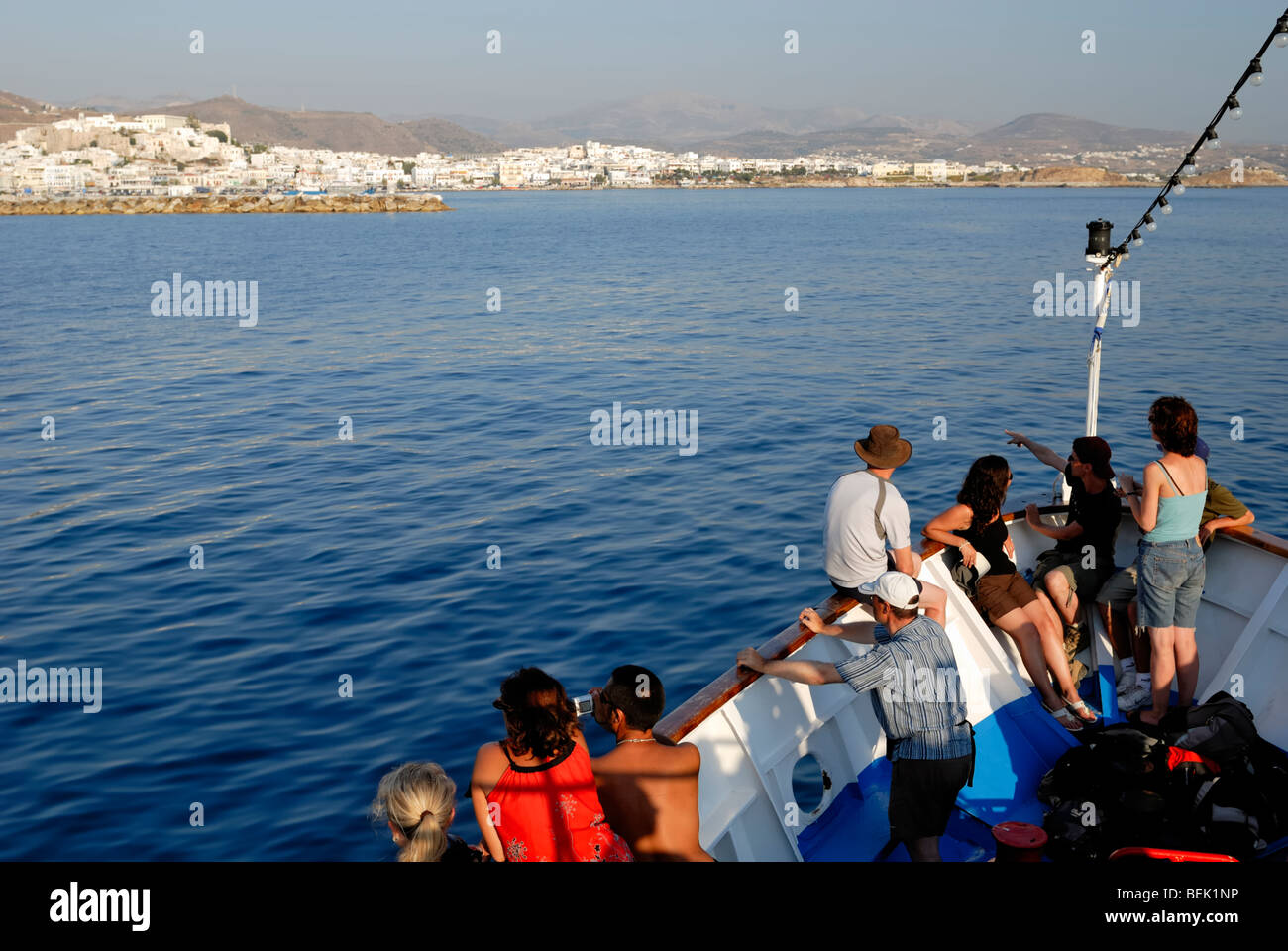Un barco de excursión de Naousa, isla de Paros, acercarse al puerto de la  ciudad de Naxos en la noche de un tranquilo día de verano. Hora, Naxos  Fotografía de stock -