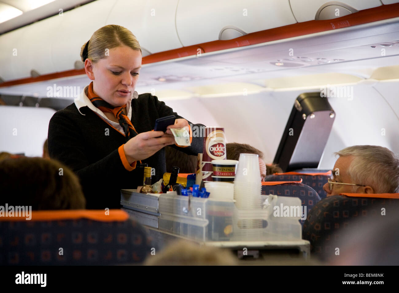 La tripulación de cabina / aire azafata sirve bebidas y bocadillos a los pasajeros de un carro carrito durante un vuelo de Easyjet Foto de stock