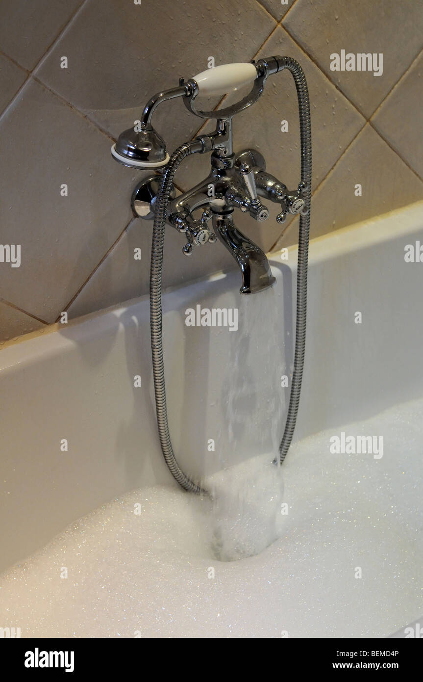 Llenar una bañera con agua fría y caliente de un grifo mezclador Foto de stock