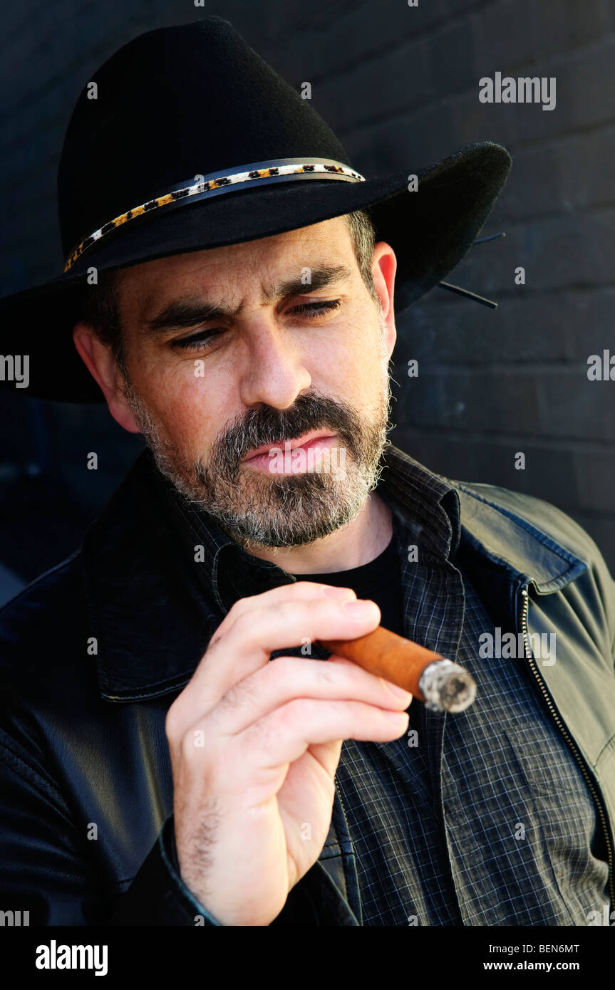 Hombre con barba en sombrero de vaquero cigarro fumar Fotografía de stock -  Alamy