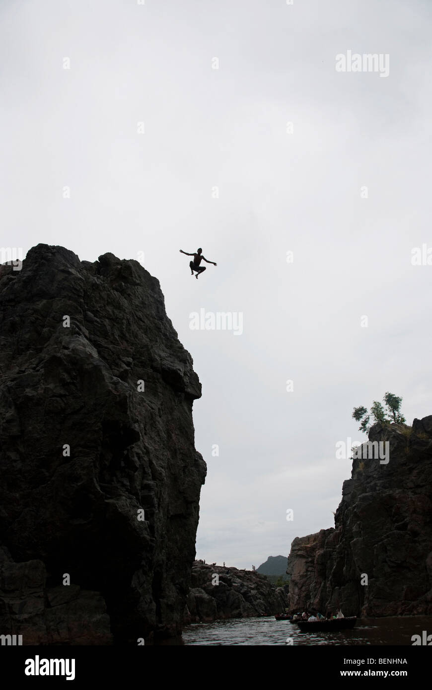 Un hombre saltando desde la cima de un acantilado Foto de stock