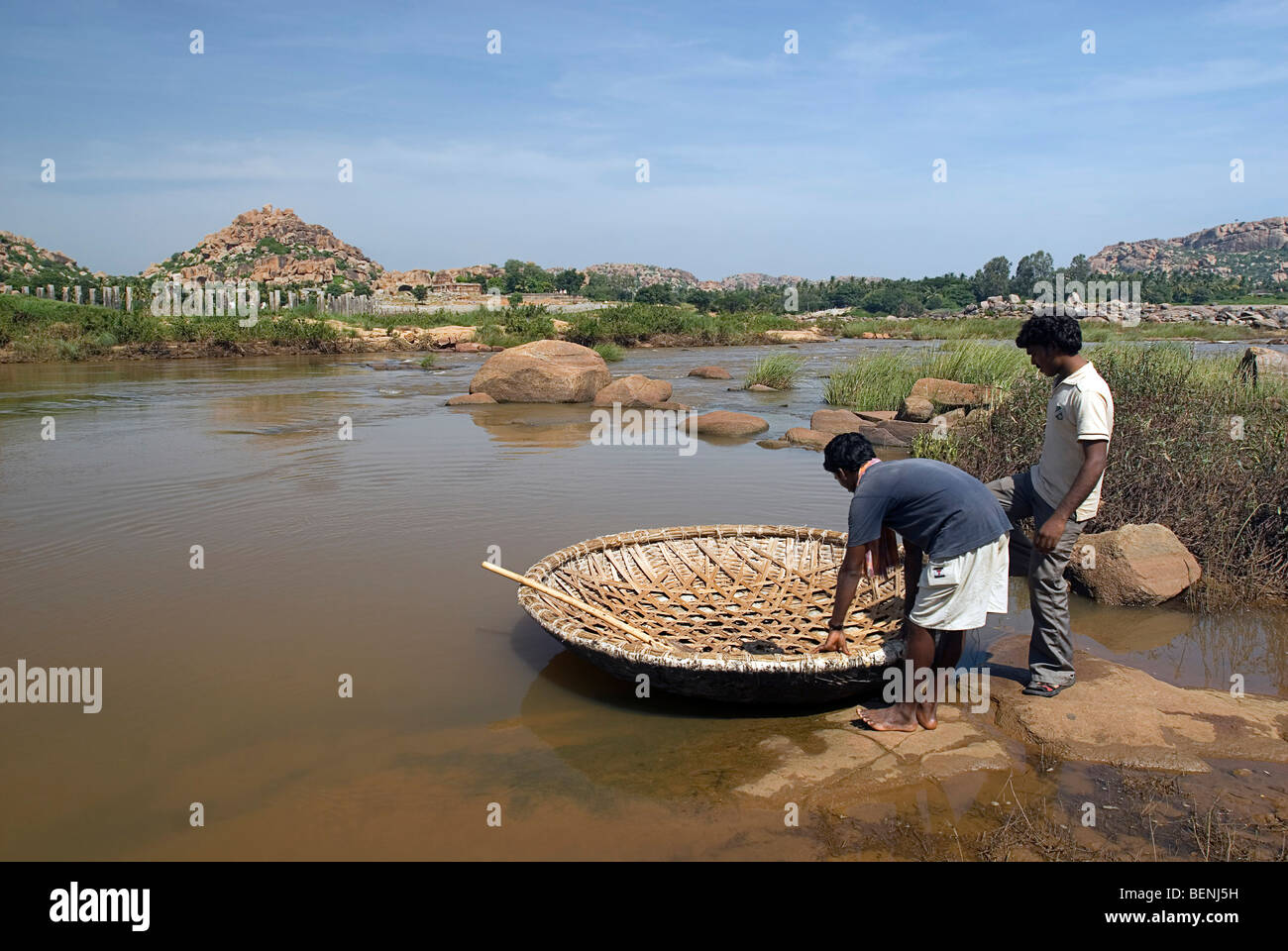 Los hombres en las orillas del río Tungabhadra Vijayanagara dentro de las ruinas de la antigua capital del Imperio Vijayanagara Hampi Foto de stock