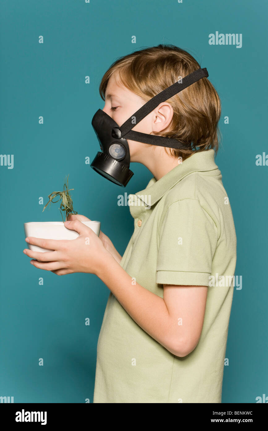 Niño usando máscara de gas, sosteniendo marchitas maceta Fotografía de  stock - Alamy