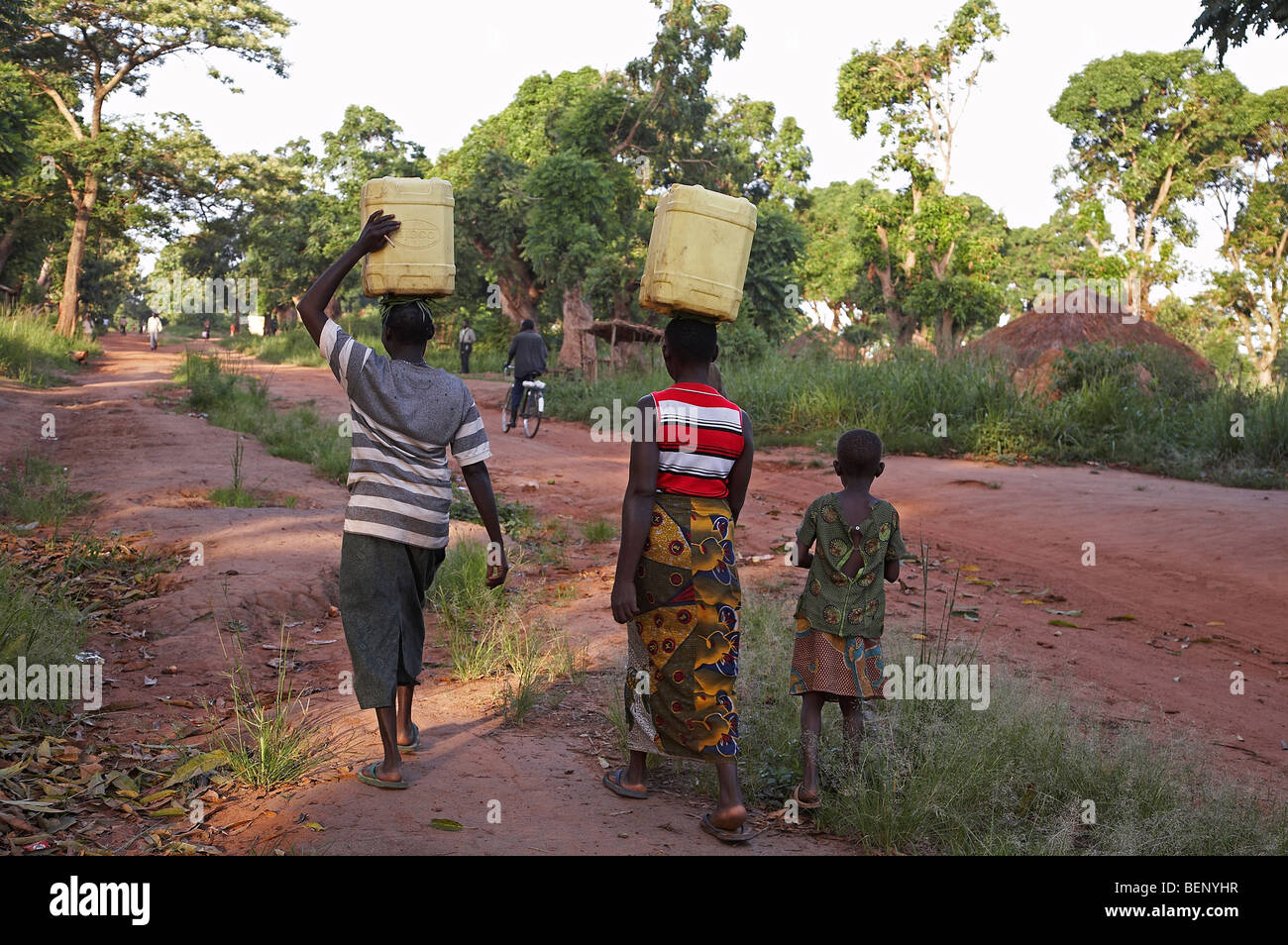 El sur de Sudán, las mujeres transportan agua proveniente de una bomba de mano bien, muy temprano en la mañana en Yei. Foto por Sean Sprague 2008 Foto de stock