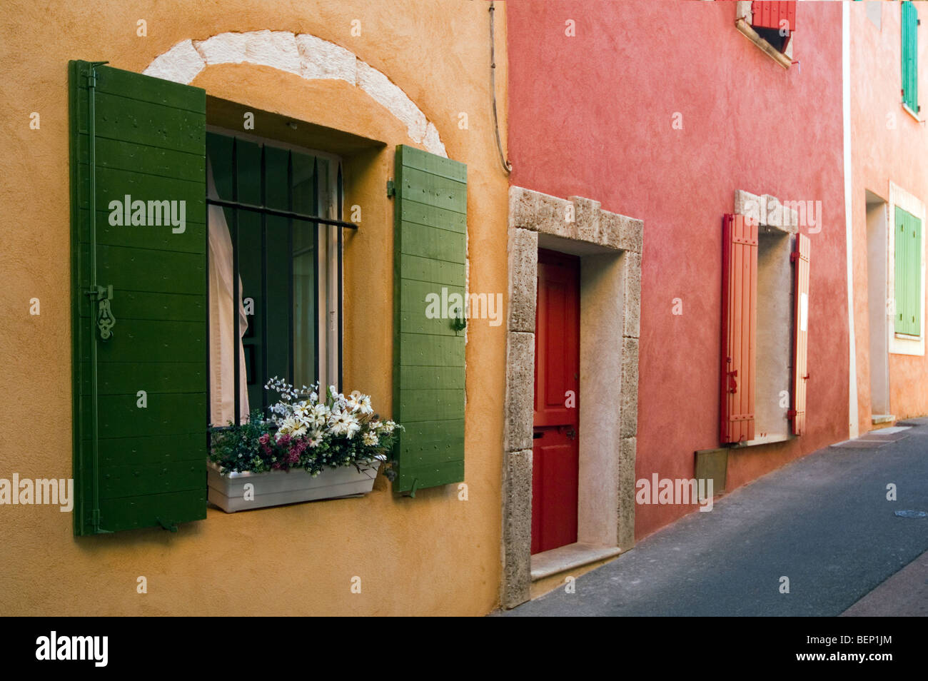 Coloridas fachadas de casas con persianas, Rosellón, Provenza, Vaucluse, Provence-Alpes-Côte d'Azur, Francia Foto de stock