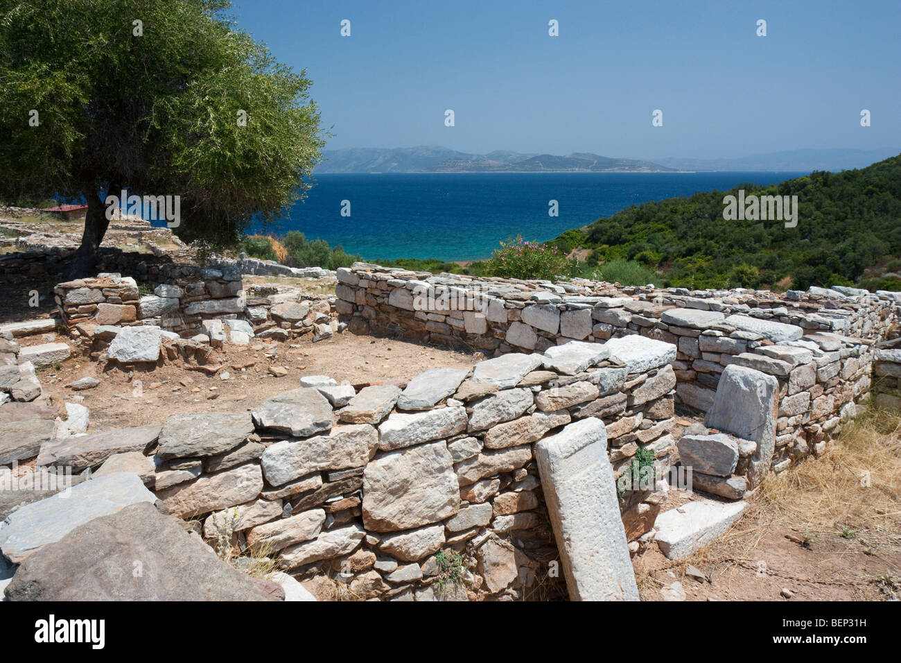 Las bases y el umbral de una antigua casa griega en Rhamnous, Grecia, con vistas al Golfo de Eubea. Foto de stock