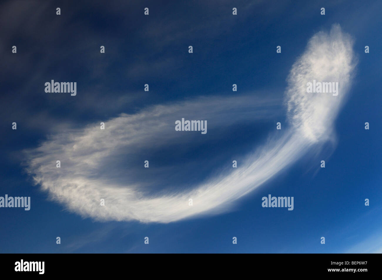 Barrido de un inusual la formación de nubes en el cielo azul parecido a un espermatozoide Foto de stock