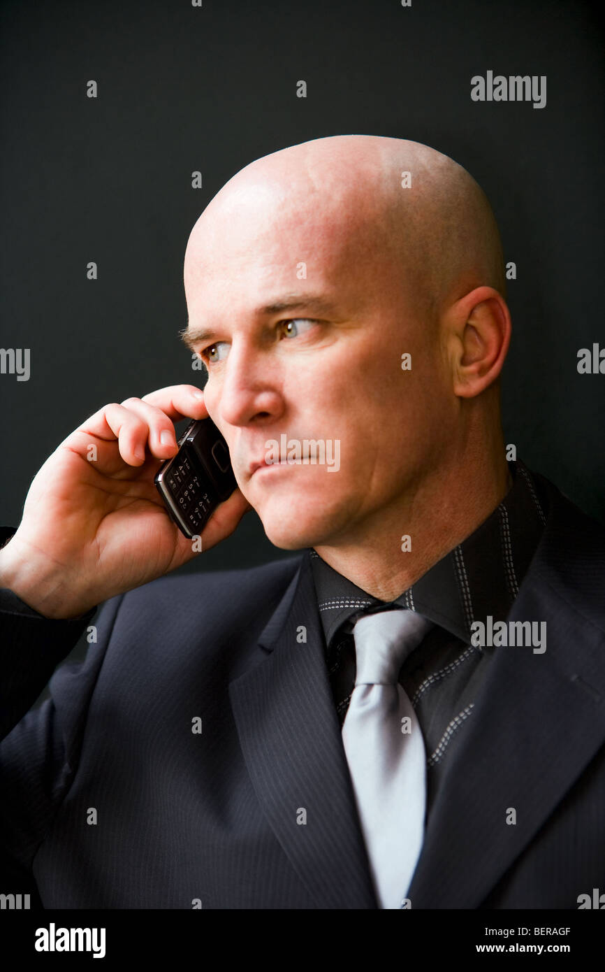 Hombre Calvo en su late 40's vistiendo un traje oscuro hablando por un  teléfono celular Fotografía de stock - Alamy