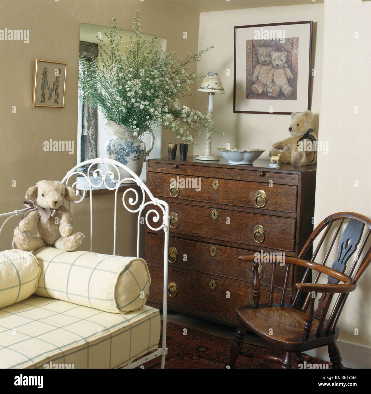 Teddy-bear y amarillo marcada reforzar en blanco día-cama de hierro en la  cabaña dormitorio con muebles antiguos cómoda y silla Windsor Fotografía de  stock - Alamy