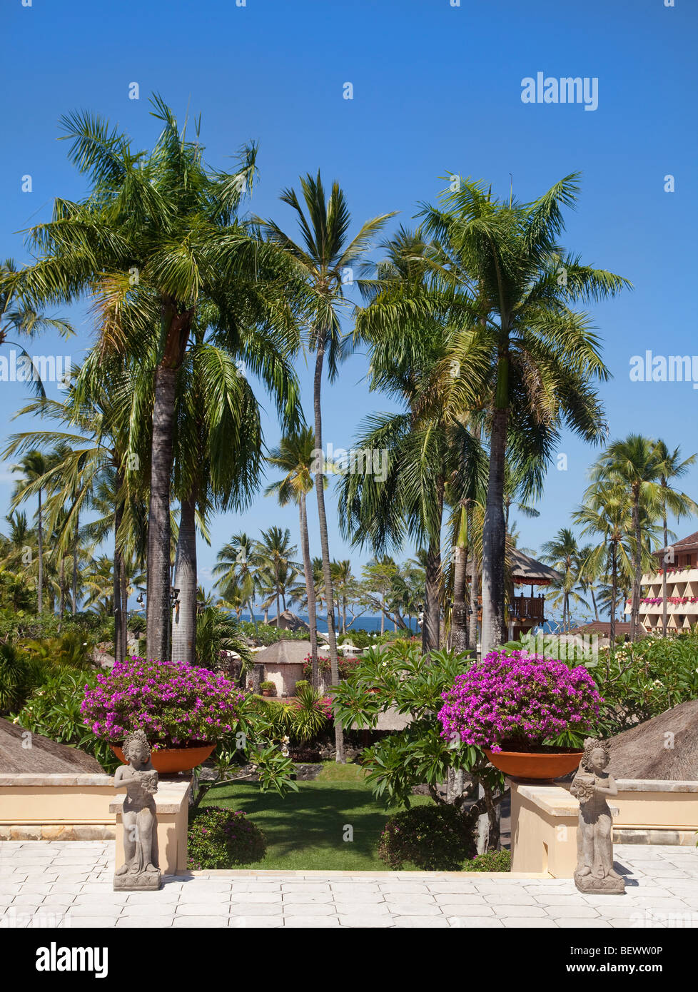 Los terrenos del hotel, de 5 estrellas, Bali, Indonesia. Día soleado, palmeras, playa en segundo plano. Foto de stock