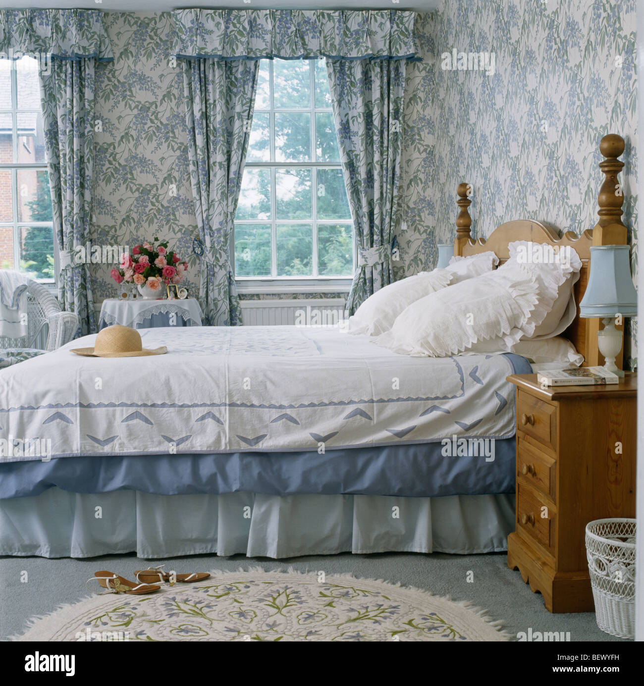 Blue+blanco papel tapiz y cortinas a juego en el país tradicional de encaje  blanco dormitorio almohadas y edredón blanco en la cama Fotografía de stock  - Alamy