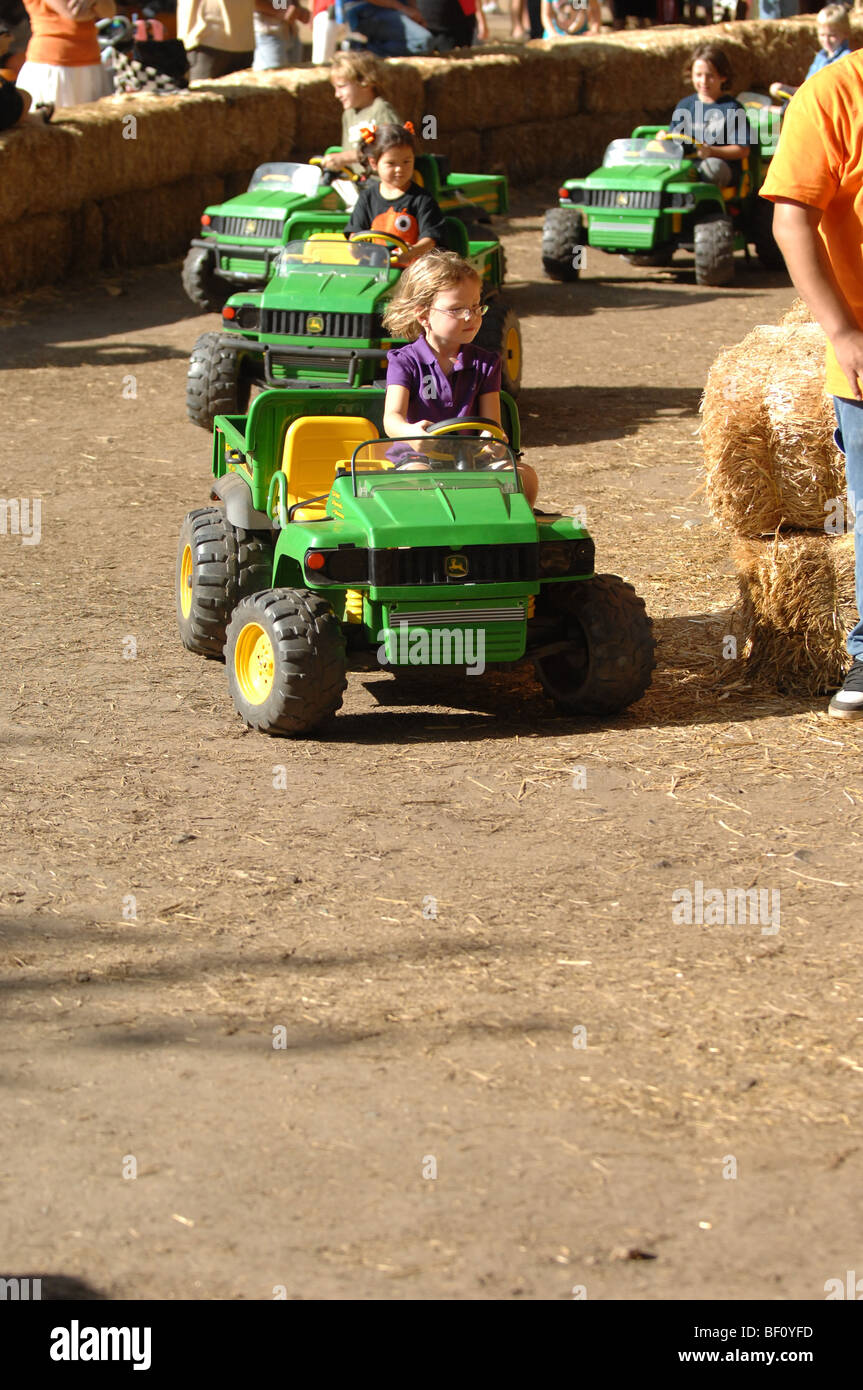 Los niños pequeños disfrutan conducir tractores de juguete tractor improvisados en una pista de carreras en el Parque Regional de Irvine en Orange, CA Fotografía de stock - Alamy