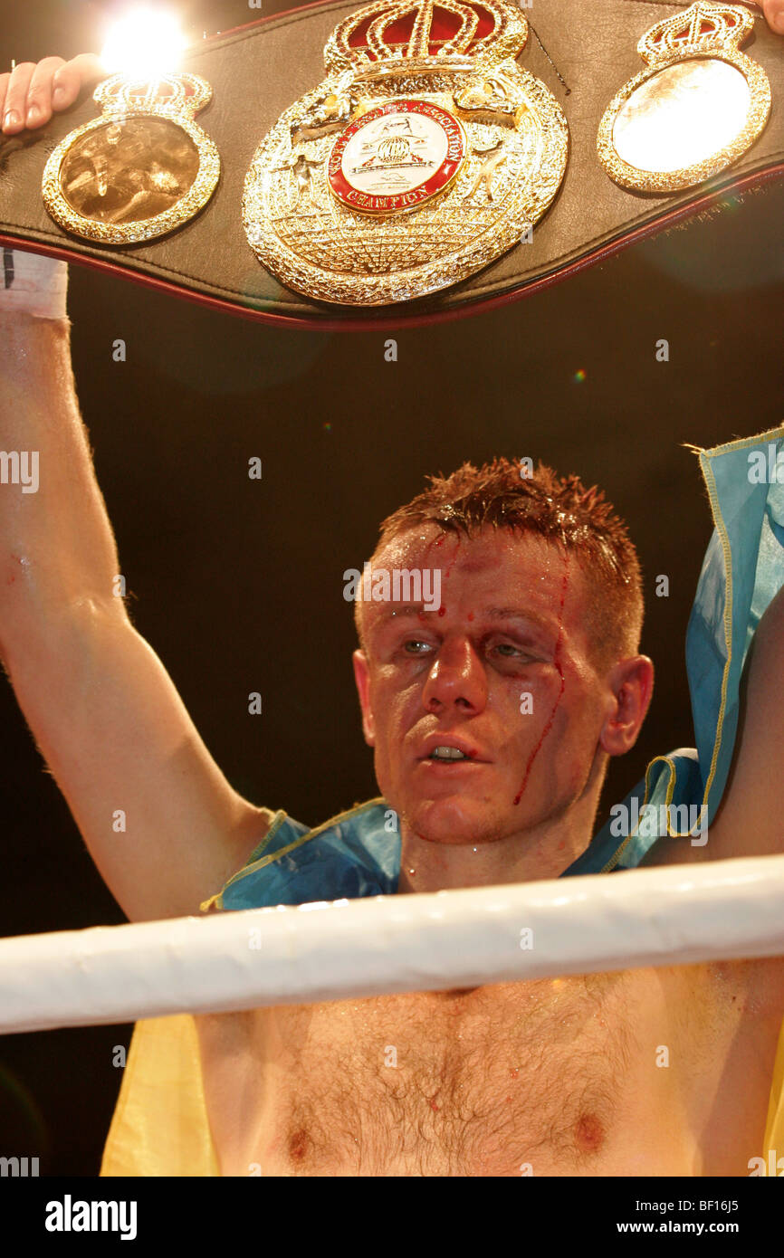 El campeón mundial de peso welter ligero de la AMB de Ucrania, Yuriy Nuzhnenko, disfruta del tiempo en el punto de luz en el Palacio de Deportes de Kiev con el cinturón en sus manos Foto de stock