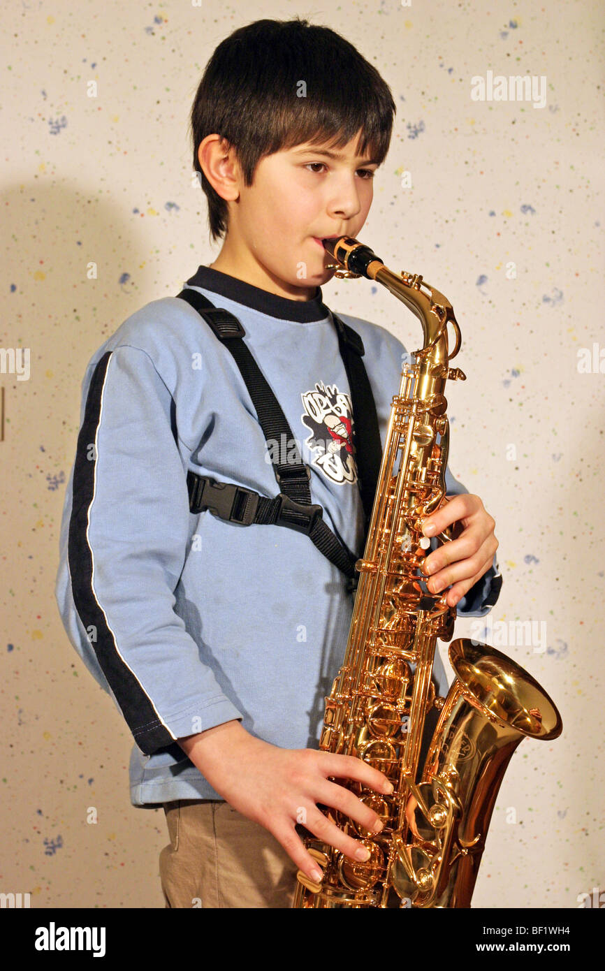Little Boy Está Jugando Un Saxofón De Juguete En El Fondo Blanco Fotos,  retratos, imágenes y fotografía de archivo libres de derecho. Image 5434748
