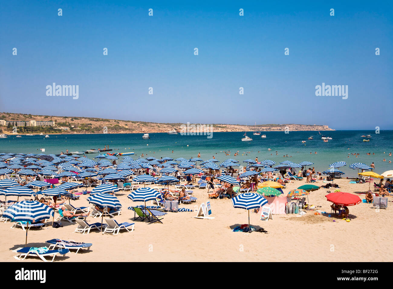 La gente en la playa con el sol, la bahía de Mellieha, Malta, Europa Foto de stock