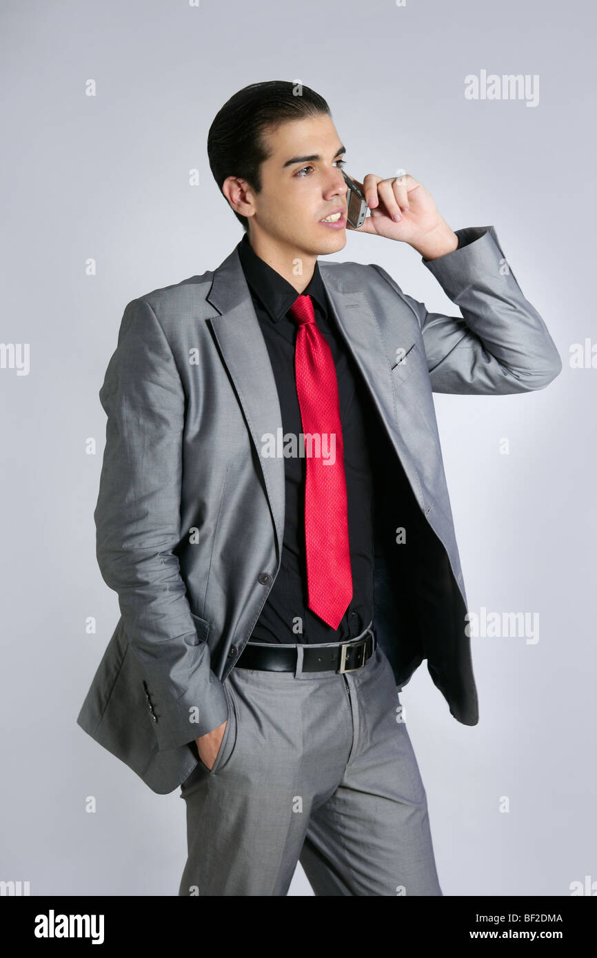 Empresario con traje gris hablando de teléfono celular con traje y corbata  roja Fotografía de stock - Alamy