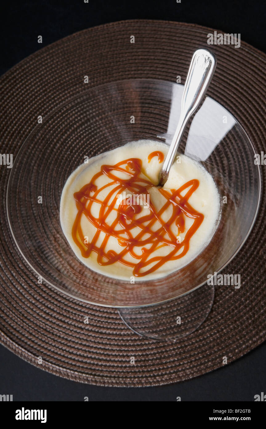 Mousse de limón con helado de crema y salsa de caramelo en una copa de martini Foto de stock