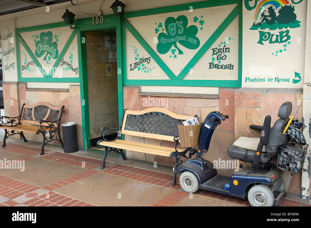 Un estilo de sillas de ruedas Scooter de movilidad está estacionado cerca de la entrada a un popular pub irlandés en el Old Towne distrito de Orange, CA. Foto de stock