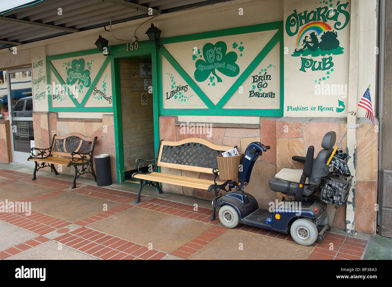Un estilo de sillas de ruedas Scooter de movilidad está estacionado cerca de la entrada a un popular pub irlandés en el Old Towne distrito de Orange, CA. Foto de stock