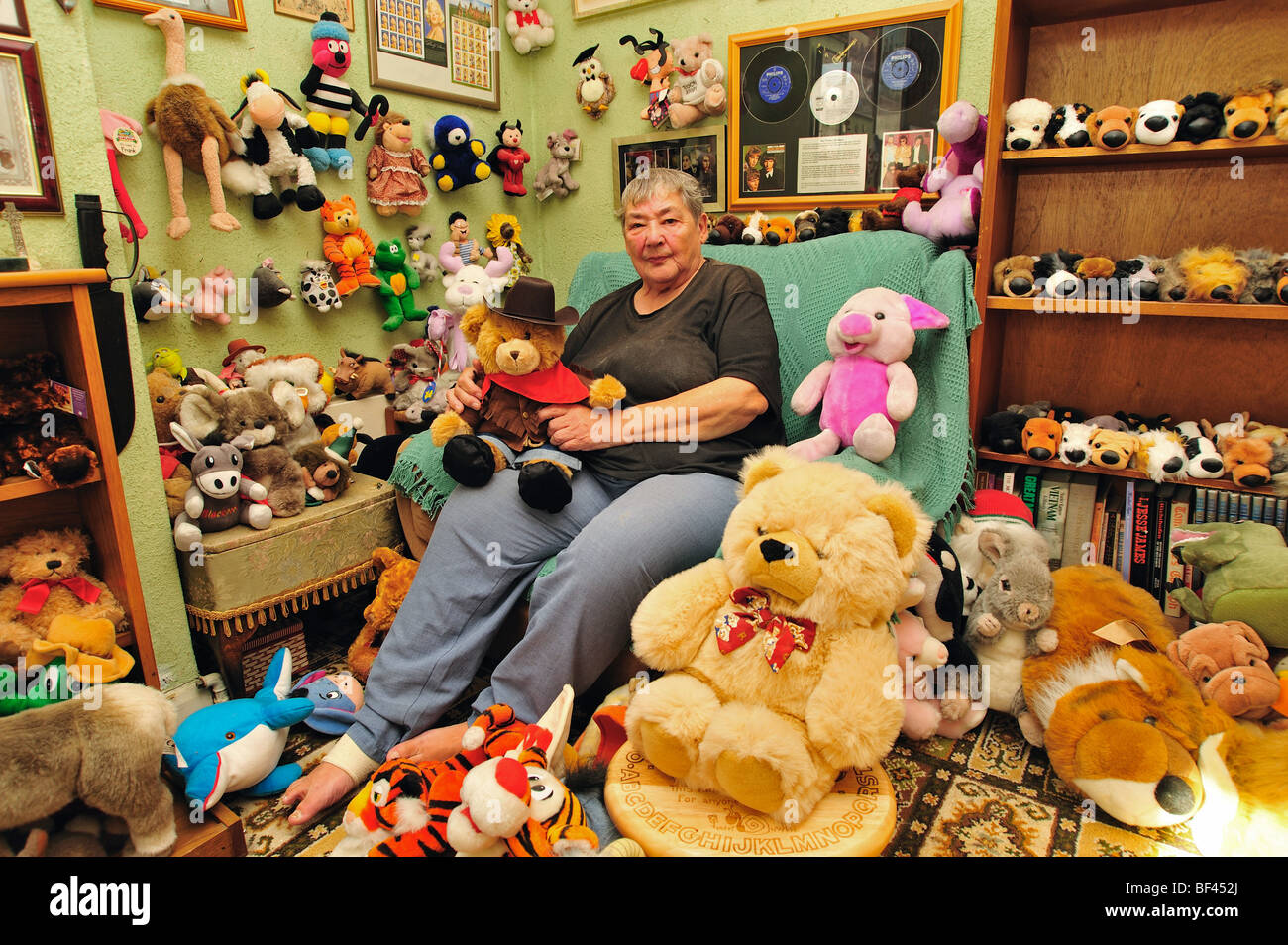 Anciana sentada con su colección de juguetes blandos en su salón Fotografía  de stock - Alamy